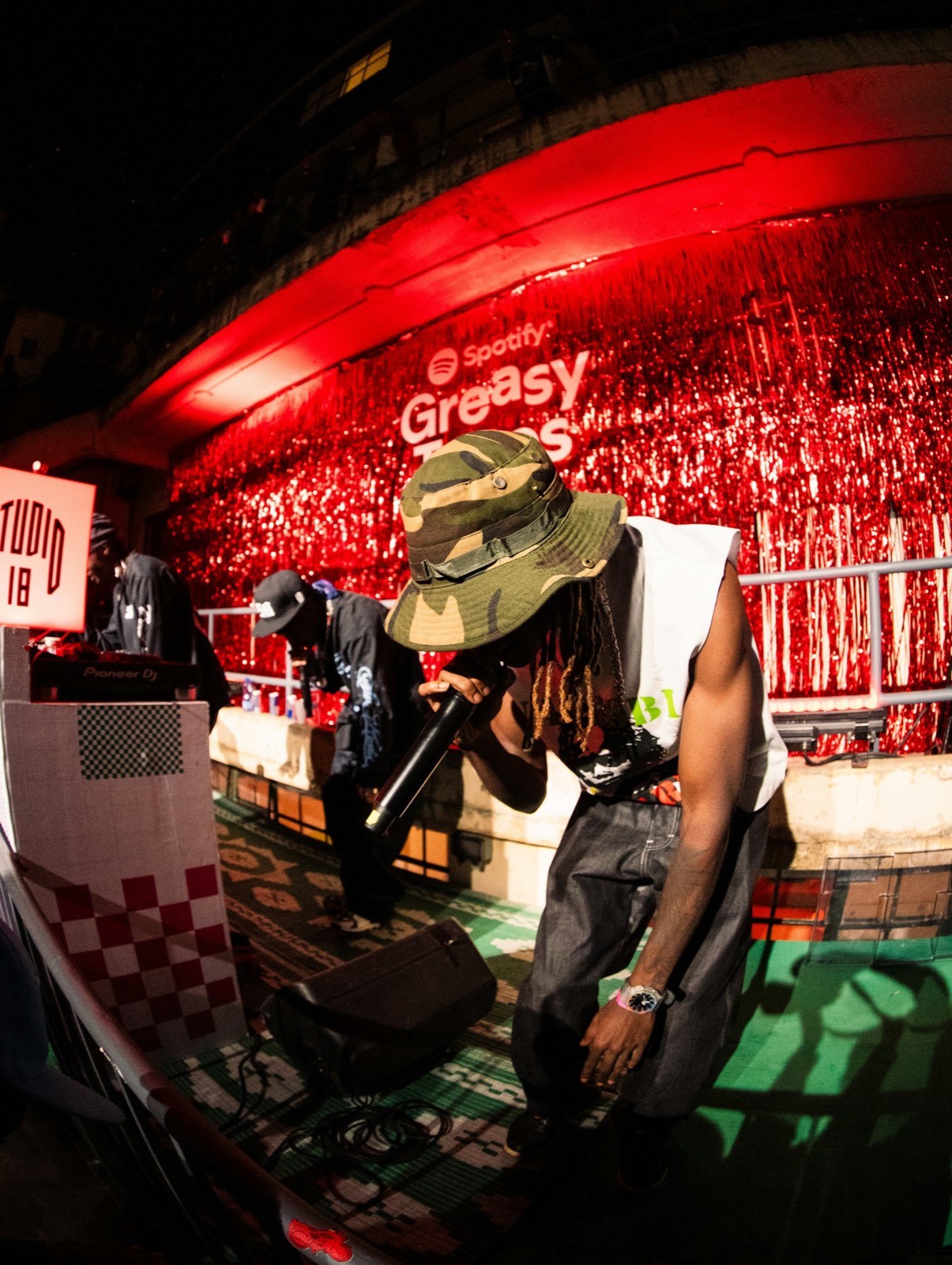A DJ performing in a red-lit booth